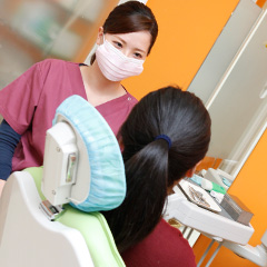 歯科衛生士から説明を受ける女性